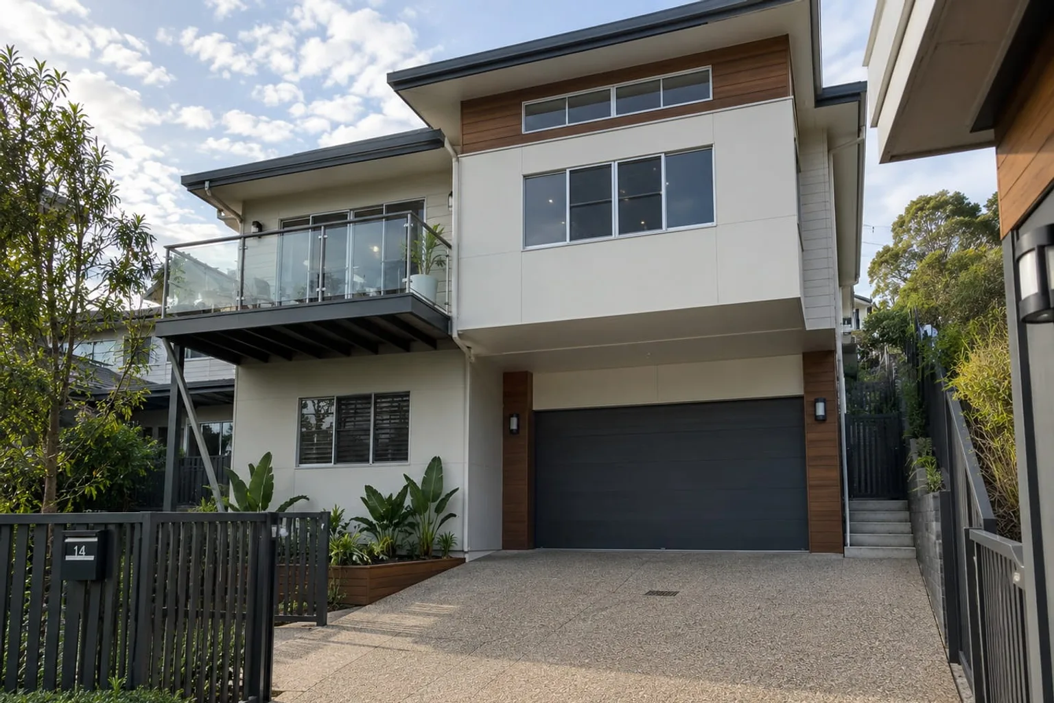 Exposed aggregate concrete driveway leading to the garage of a modern two-storey Mackay home
